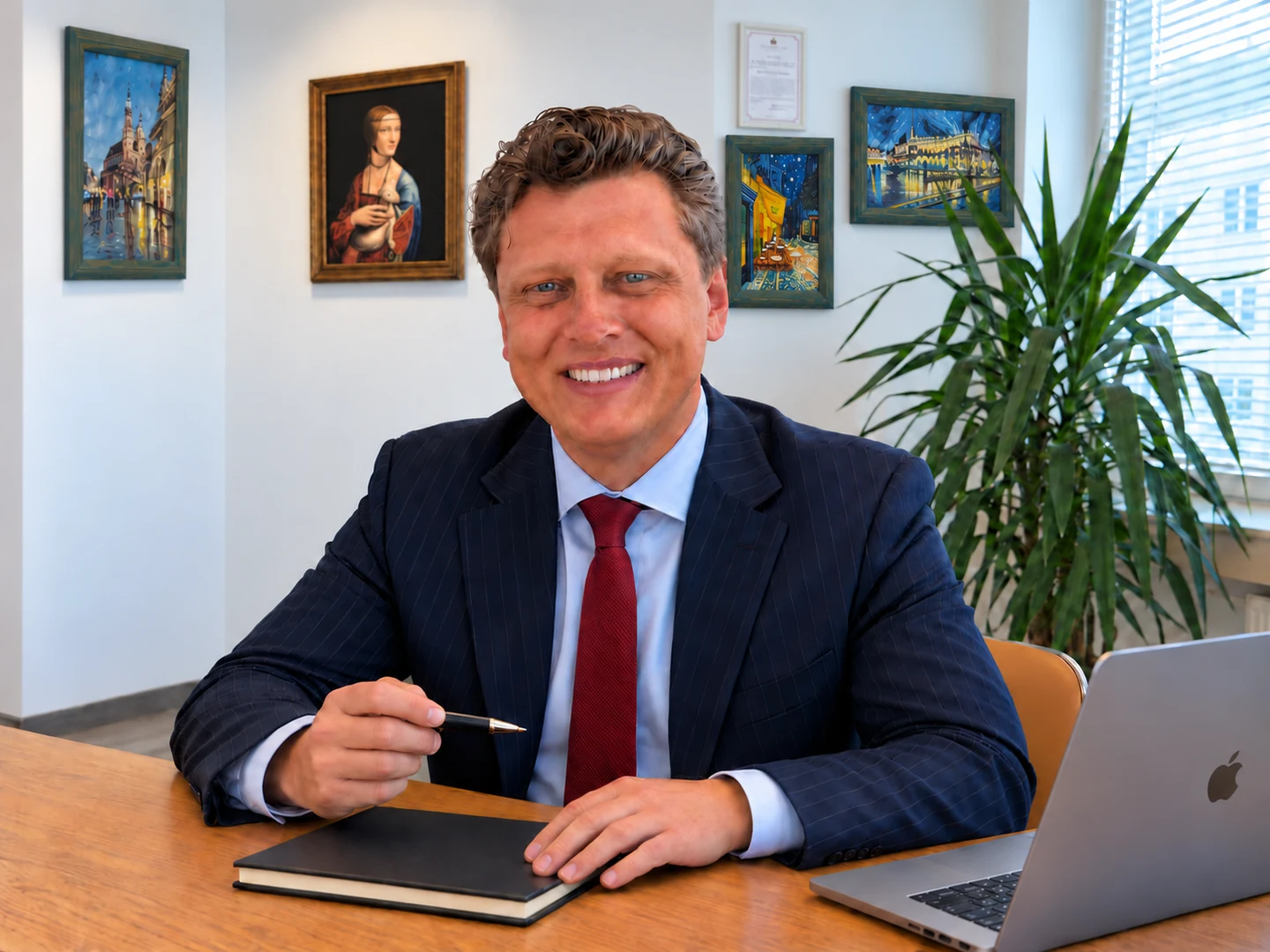 Vadym Rekel przy laptopie i notesie w kancelarii tłumaczeń w Krakowie